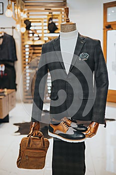 Sophisticated suit with derby shoes and a bag on the mannequin on the display