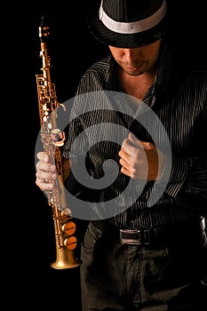 Soprano saxophone in the hands of a guy on a black background photo