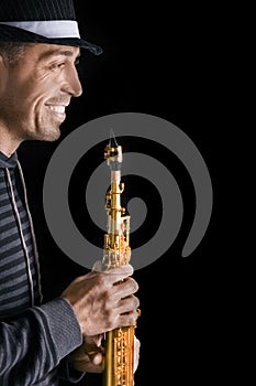 soprano saxophone in the hands of a guy on a black background photo