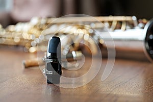 Soprano Saxophone Mouthpiece, Closeup Woodwind Instrumental Equipment on Blur Saxophone Background. photo