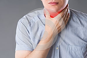 Sore throat, men with pain in neck, studio shot on gray background