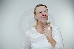 sore throat vocal cords tense woman can& x27;t speak she sticks out tongue looks up wrinkled hand she holds throat white
