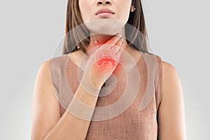 Sore throat woman on gray background photo