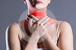 Sore throat, woman with pain in neck, gray background