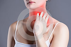 Sore throat, woman with pain in neck, gray background