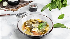 Sorrel soup with egg in bowl. Traditional Latvian soup. Skabenu zupa, Food recipe background. Close up, top view