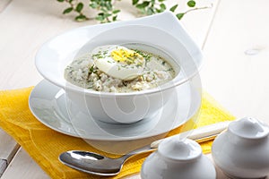 Sorrel soup with egg in white bowl