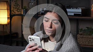 Sorrowful Caucasian Woman with Phone on Sofa in the Living Room