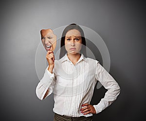 Sorrowful woman holding mask