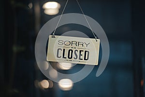 Sorry we are closed sign hanging outside a restaurant, store, office or other. Closed sign in a shop showroom with reflections bok