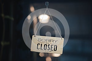 Sorry we are closed sign hanging outside a restaurant, store, office or other. Closed sign in a shop showroom with reflections bok