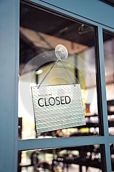 Sorry we are closed sign hanging on the window blue door shop