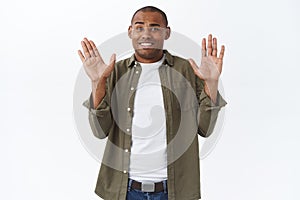 Sorry, dont mind me. Portrait of awkward and embarrassed african-americna man, apologizing, raising hands in surrender photo