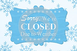 Sorry We`re Closed Due to Weather message on a wood sign