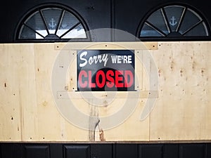 Sorry we `re closed sign on door and wooden board