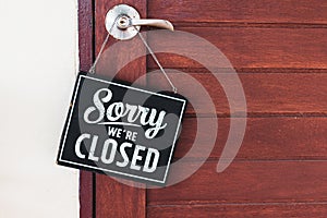 Sorry we\'re closed sign. grunge image hanging on cafe wooden door