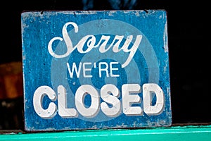 Sorry, weâ€™re closed sign standing in a shop window