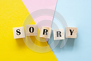 Sorry wordmade from wooden blocks over colorful backgrounds