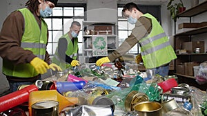 Sorting and Recycling Facility. Workers on a conveyor belt manually sort glass, paper waste, metal and plastic