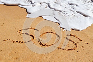 SOS help message in the sand
