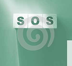 SOS symbol on wooden cubes. Save Our Souls call for help concept