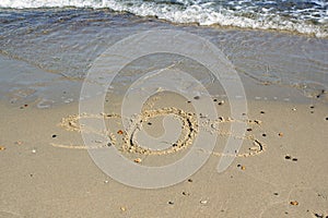 SOS - word drawn on the sand beach with the soft wave.