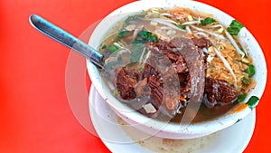 Soto kerbau or Soto beef buffalo, culinary typical of kudus central java - indonesia, with red background. photo