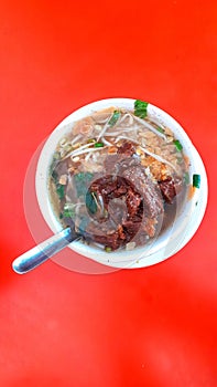 Soto kerbau or Soto beef buffalo, culinary typical of kudus central java - indonesia, with red background.