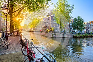 Soul of Amsterdam. Early morning in Amsterdam. Ancient houses, a bridge, traditional bicycles, canals and the sun shines through