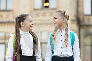 Soulmate friends. Cute schoolgirls with long ponytails looking charming. Ending of school year. Cheerful smart