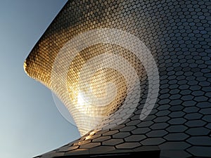 soumaya museum from a perspective towards the clear sky at sunset reflected in the building photo