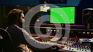 Sound designer watches online tutorials via greenscreen monitor