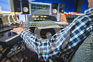 Sound editor engineer working at studio with mixing panel, mixing music and sound, stage sound mixer, boutique recording studio,