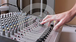 Sound Engineer, DJ Moves Sliders with Fingers on Audio Mixer in Recording Studio