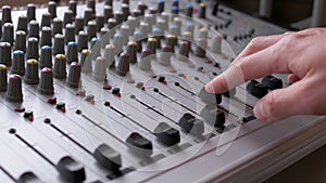 Sound Engineer, DJ Moves Sliders with Fingers on Audio Mixer in Recording Studio