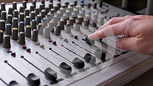 Sound Engineer, DJ Moves Sliders with Fingers on Audio Mixer in Recording Studio