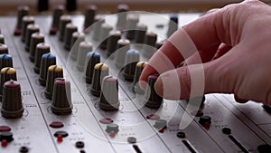Sound Engineer, DJ Moves Sliders with Fingers on Audio Mixer in Recording Studio