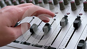 Sound Engineer, DJ Moves Sliders with Fingers on Audio Mixer in Recording Studio