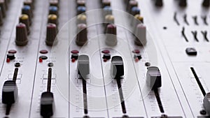 Sound Engineer, DJ Moves Sliders with Fingers on Audio Mixer in Recording Studio