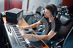 Sound engineer in headphones working and mixing music indoors in the studio