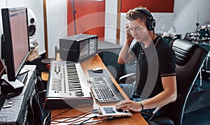 Sound engineer in headphones working and mixing music indoors in the studio