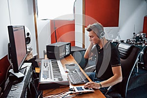 Sound engineer in headphones working and mixing music indoors in the studio