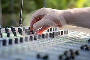 Sound engineer at mixing desk at open air - might be a wedding or a concert