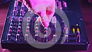 Sound Engineer Move Faders Level on Audio Mixer Console in Neon Light Close-Up