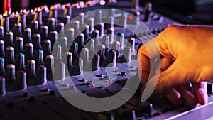 Sound Engineer Moves Faders Up and Down on Audio Mixer in Neon Light Close-Up