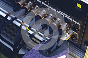 Sound engineer plugging audio cable on studio system boxes