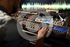 Sound engineer at recording studio mixing console