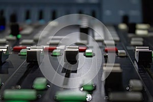 Sound engineer`s mixing console, close-up of faders and sliders, selective focus, toning.