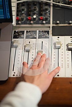 Sound engineer working with mixing console panel