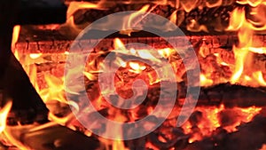 Sound. Extreme close-up video of a burning picnic bench at the end of a party by a body of water.